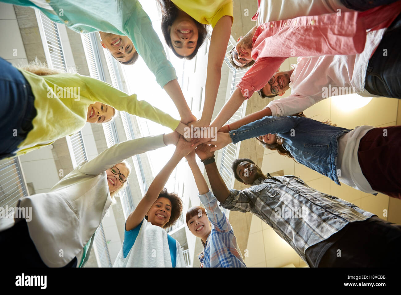 group of international students with hands on top Stock Photo - Alamy