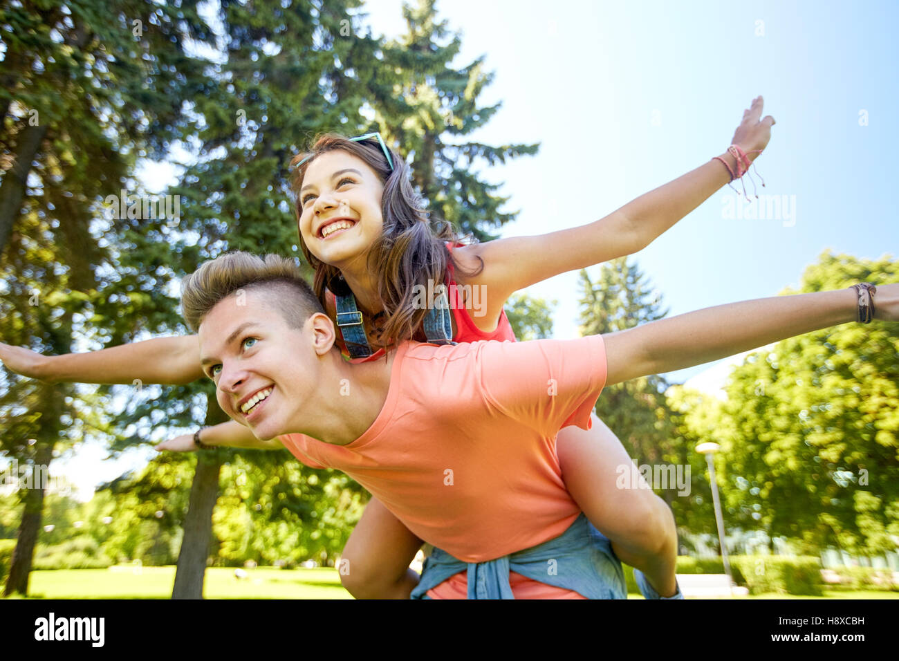 happy teenage couple having fun at summer park Stock Photo - Alamy