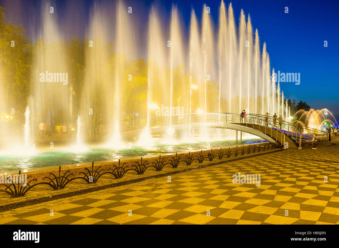 The fountains create the bright water wall in the air, separating two sides of Primorsky Park for a moment, Batumi, Georgia. Stock Photo
