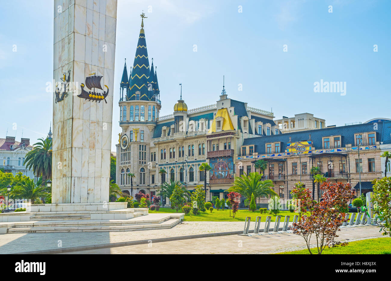 The white stone column of Medea monument, decorated with Argo ship with the astronomical tower on the background, Batumi, Georgia. Stock Photo