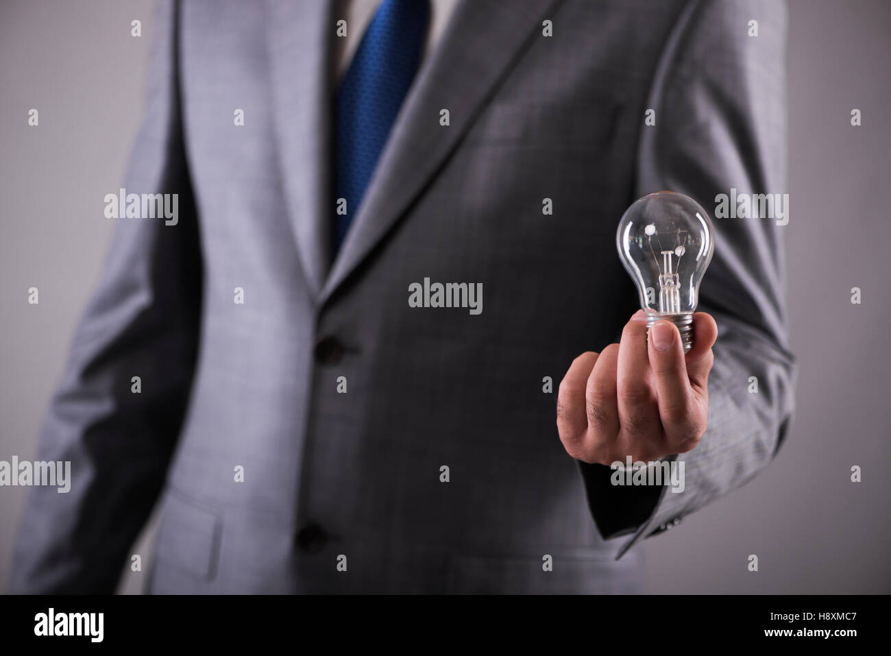 Businessman holding light bulb in creativity concept Stock Photo - Alamy