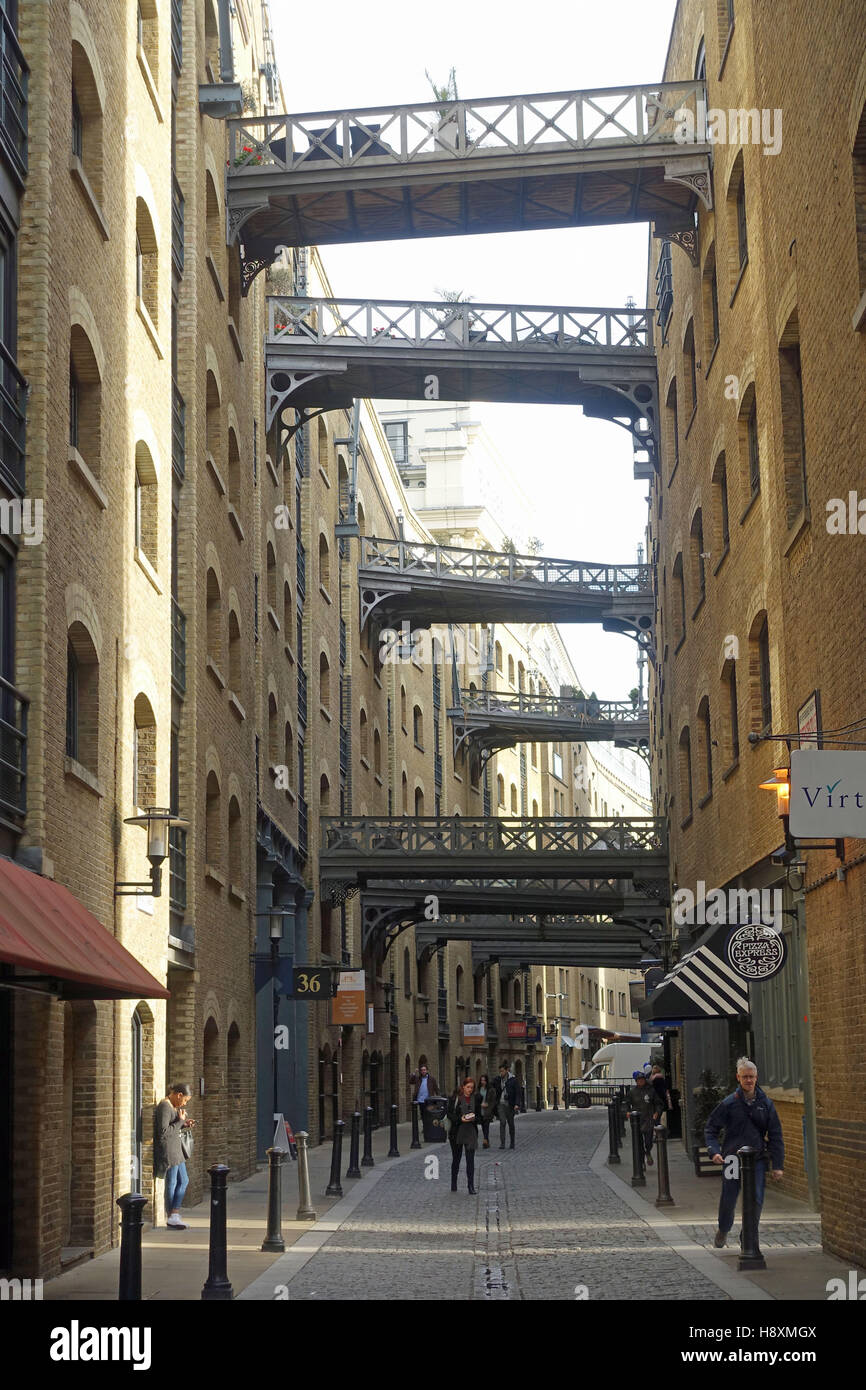 View along Shad Thames looking up at the overhead walkways between warehouse apartments of Butlers Wharf Stock Photo
