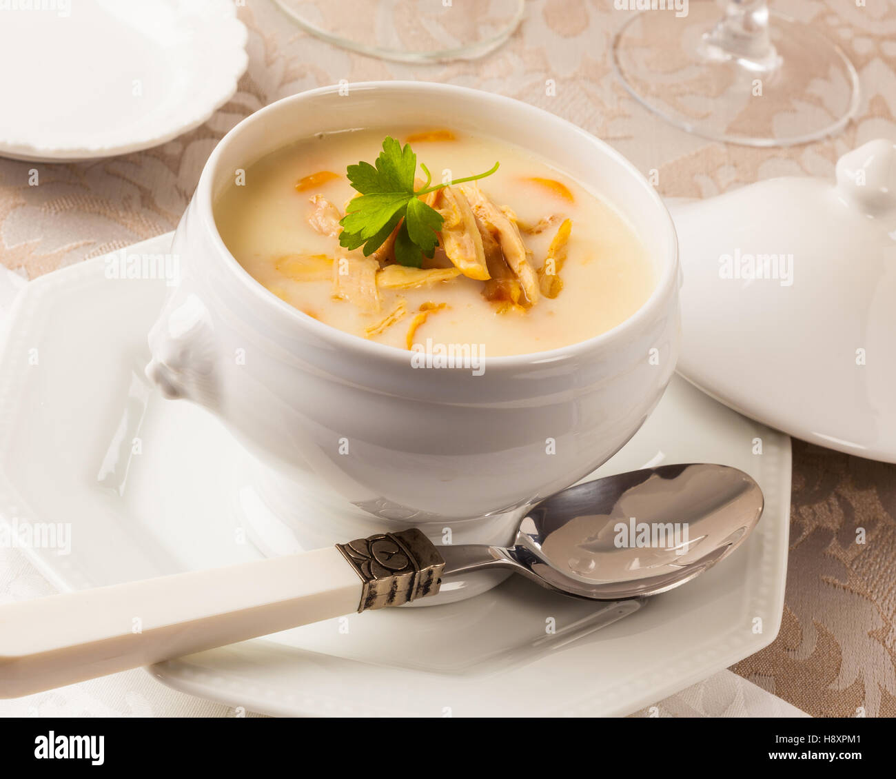 A bowl of chicken cream soup on a dinner table. Stock Photo