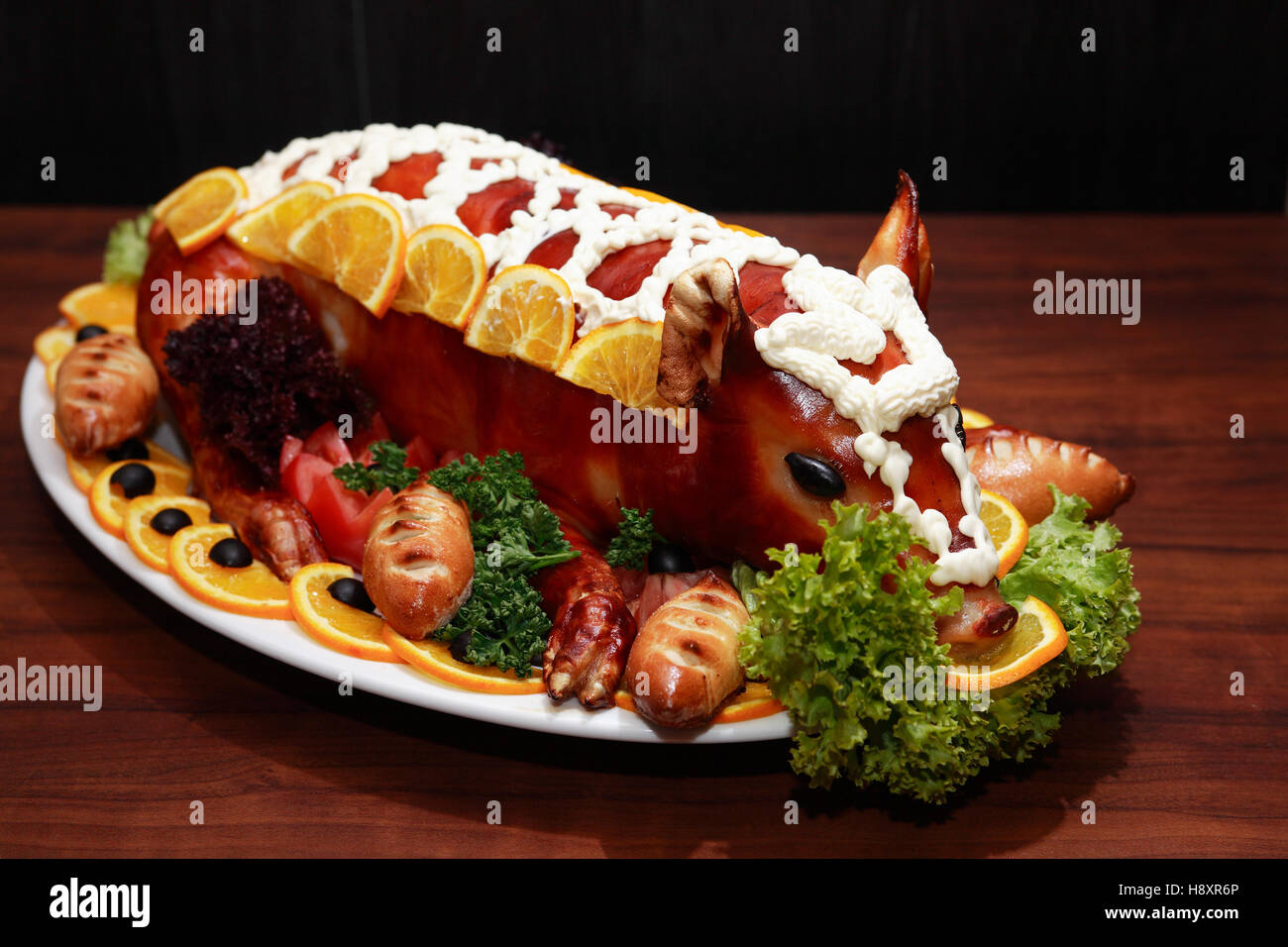 Roast suckling pig decoration with vegetables on big plate Stock Photo