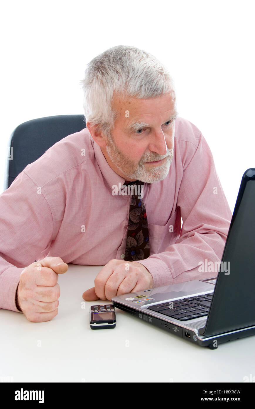 Elderly businessman, working on a laptop, annoyed Stock Photo