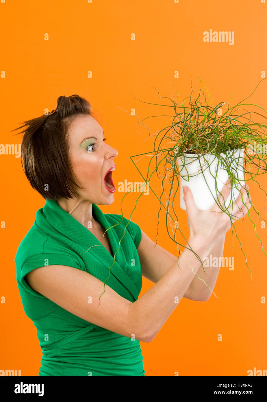 Young woman screaming at potted plant Stock Photo