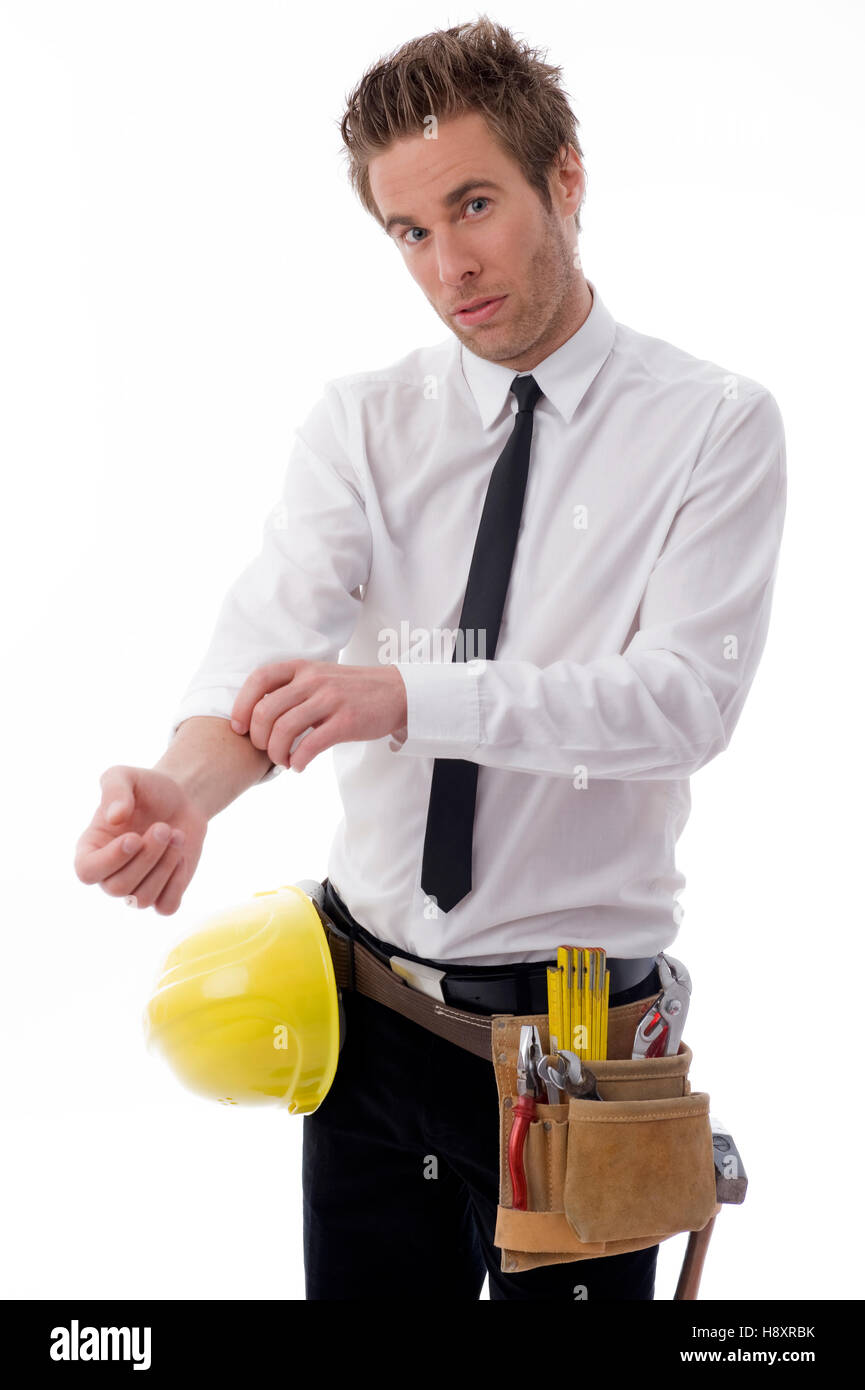 Young businessman with a tool belt and a hard hat, rolling up his