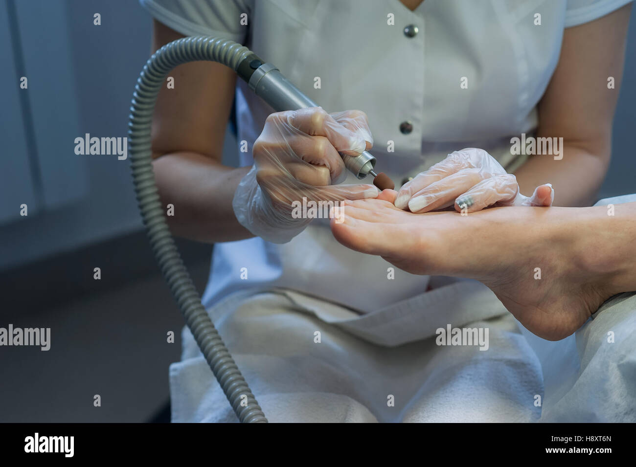 profesional nail technician sanding nails with machine Stock Photo