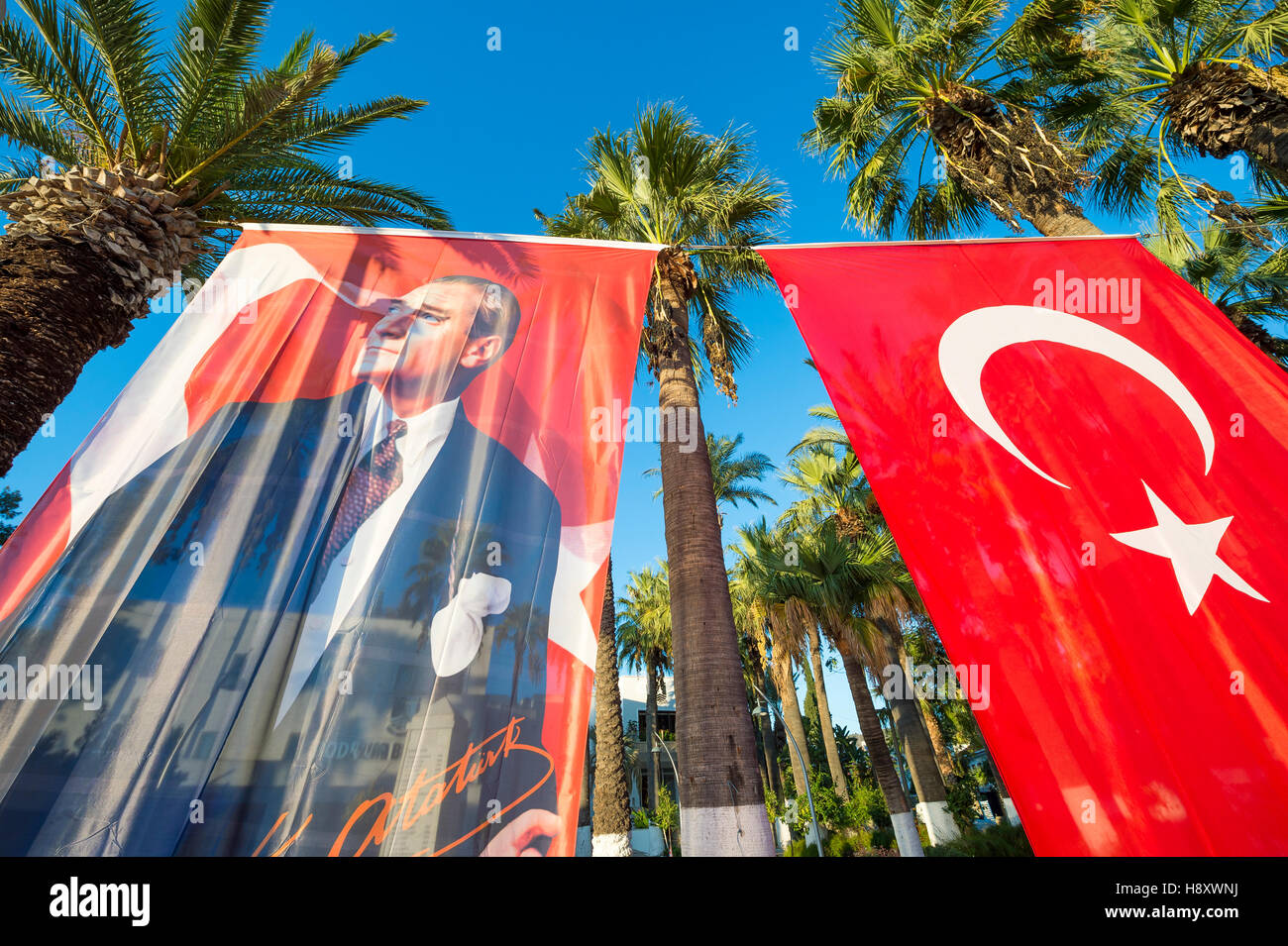 BODRUM, TURKEY - OCTOBER 6, 2016: Turkish flag hanging next to portrait of Mustafa Kemal Atatürk, the founder of the Republic. Stock Photo
