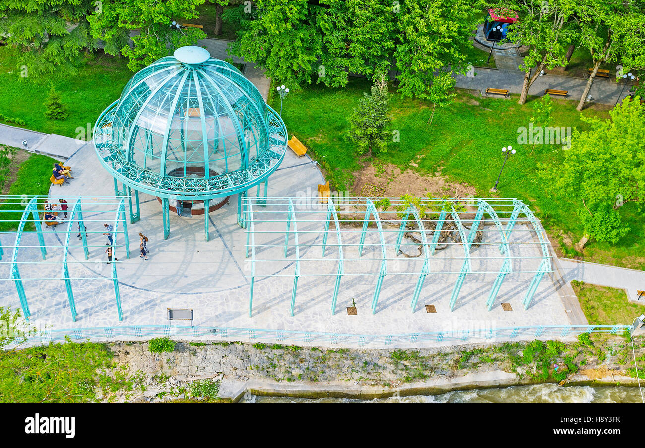 The Borjomi cable car rides over the Mineral Water Park with its blue pavilion, hiding the water source, Georgia. Stock Photo