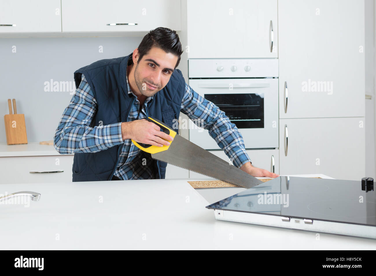 Man using saw in kitchen Stock Photo Alamy