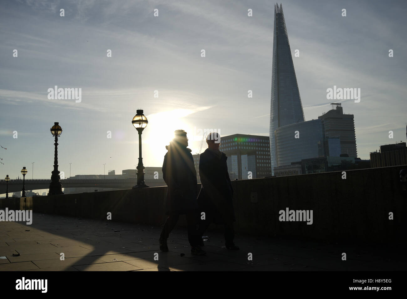 Pair walk along the Thames river with the Shard building in background Stock Photo