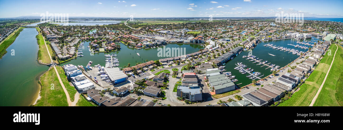 Aerial panorama of Patterson River and Patterson Lakes suburb on bright sunny day. Houses nested near water with moored boats ne Stock Photo