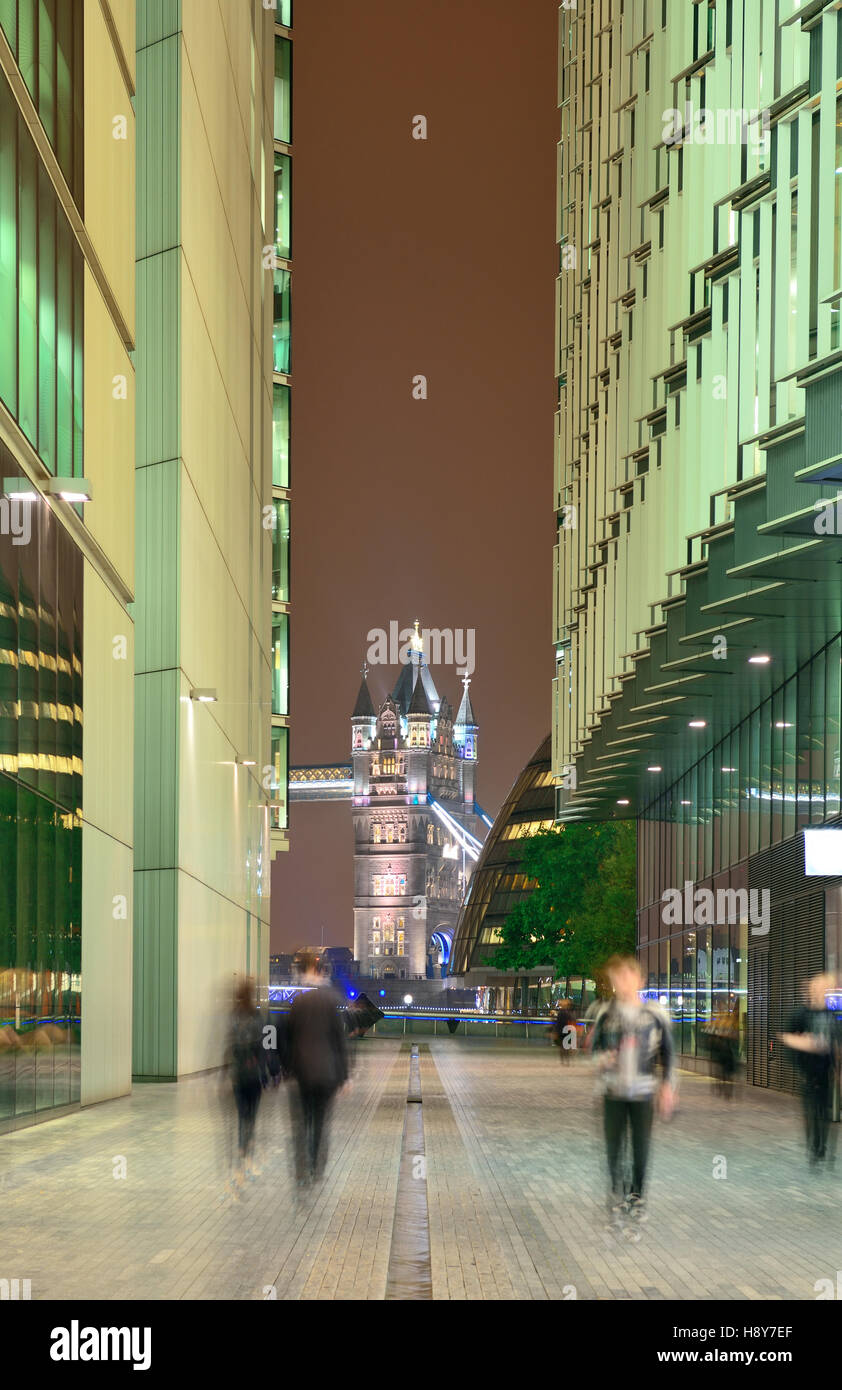 London street view at night with office buildings and pedestrian. Stock Photo