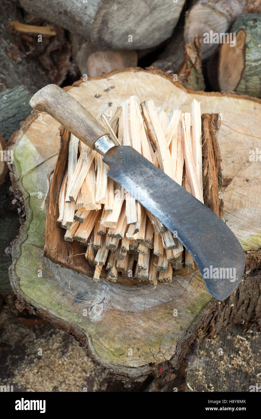 Coa knife or machete on a pile of firewood sticks Stock Photo