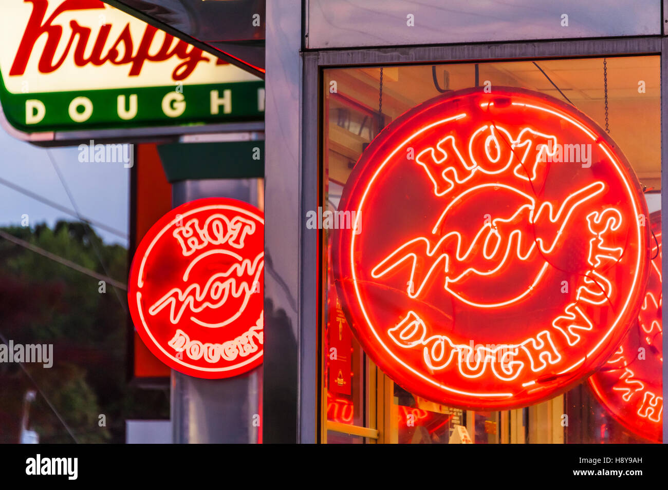 "Hot Now" neon signs glowing at Krispy Kreme Doughnut shop near Stock