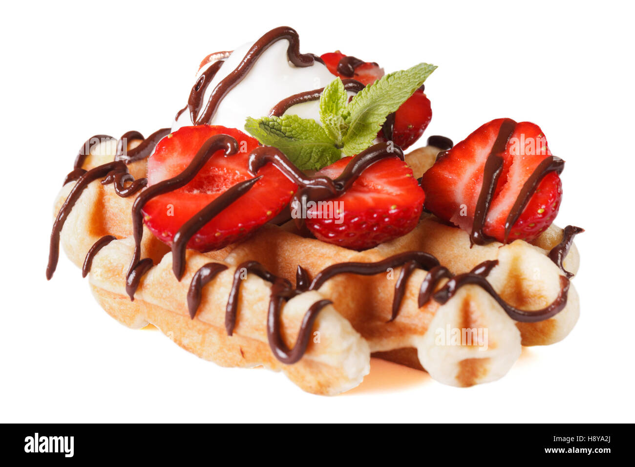 Belgian waffles with strawberries and chocolate topping close up isolated on white background Stock Photo