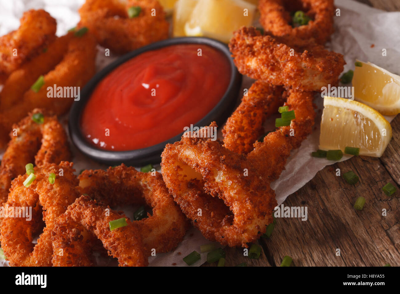 Delicious Fried calamari rings close-up on a table, and tomato sauce