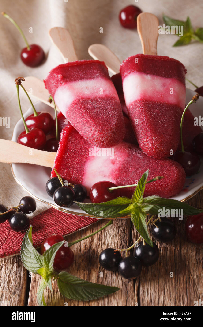 Tasty berry ice cream with mint close up on a stick on the table. vertical Stock Photo