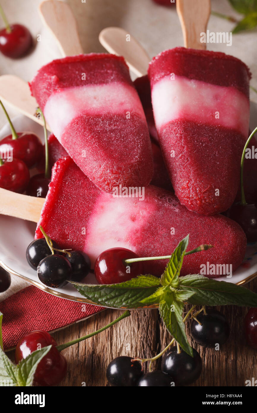Cherry ice cream with mint close up on a stick on the table. vertical Stock Photo