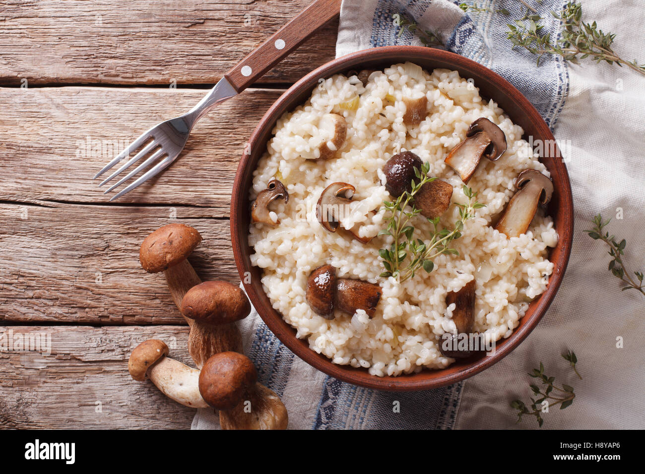 risotto with porcini mushrooms and thyme close-up on the plate on the table. horizontal view from above Stock Photo