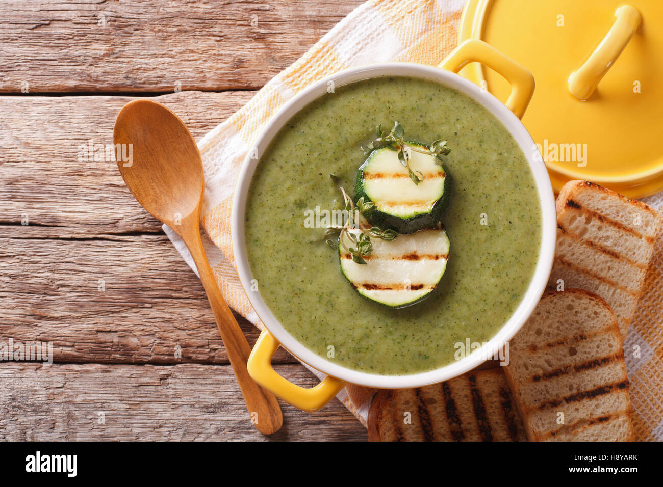 Summer Zucchini soup with thyme closeup in a yellow saucepan