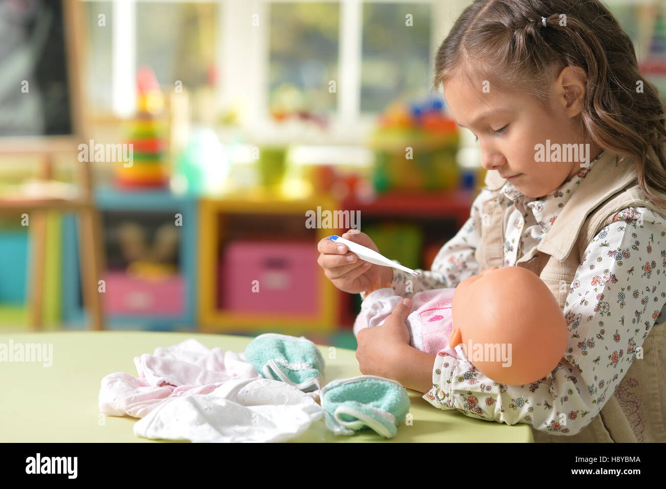 Girl playing with baby doll Stock Photo - Alamy