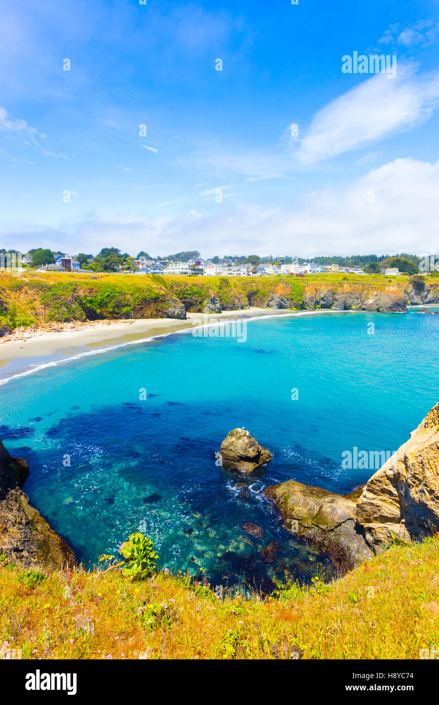 Beautiful azure cove below the cliffs near Main Street on a blue sky day in Mendocino community in California. Vertical Stock Photo