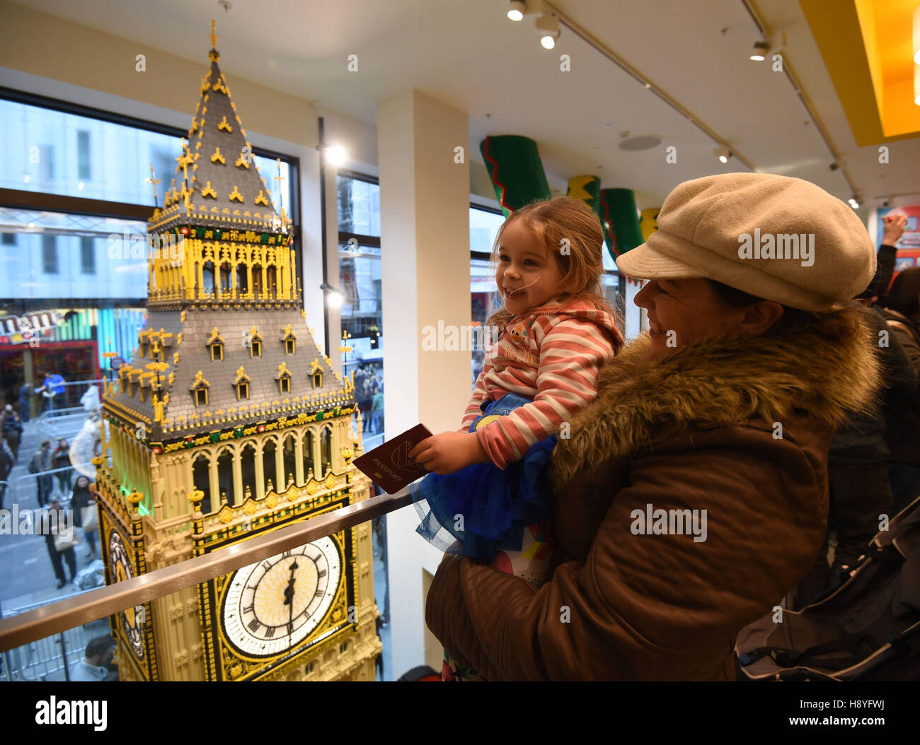 Keira (no age given) is held up to see a Lego model of Big Ben inside the 'world's largest Lego store' in Leicester Square, London. Stock Photo