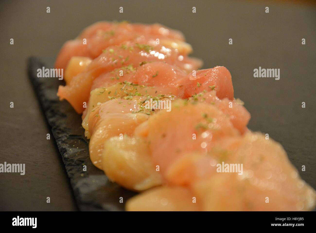 Close-up on spiced chicken meat on a slate plate Stock Photo
