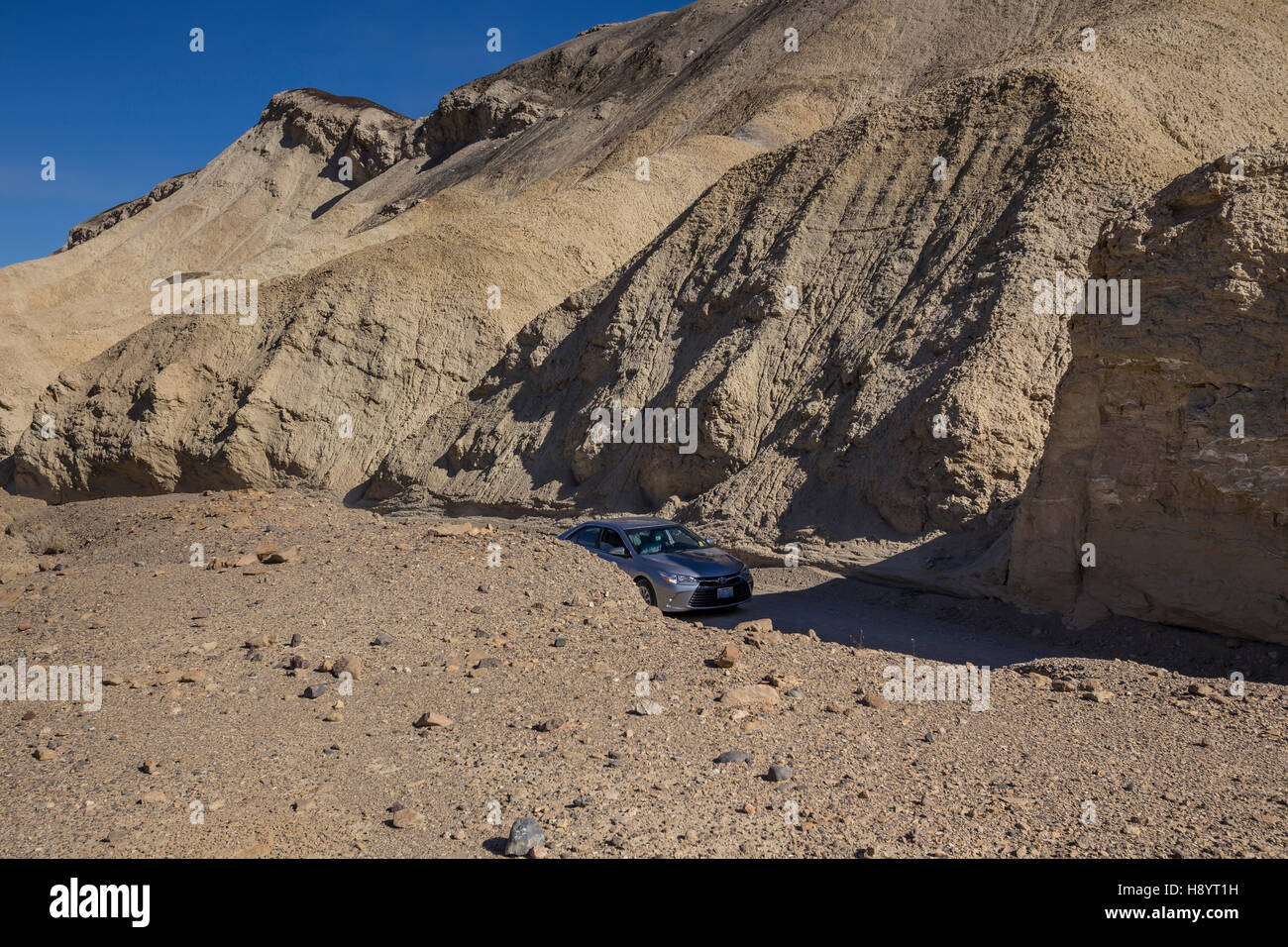 Car, tourists, dry wash, Twenty Mule Team Canyon Road, Twenty Mule Team Canyon, Death Valley National Park, California Stock Photo