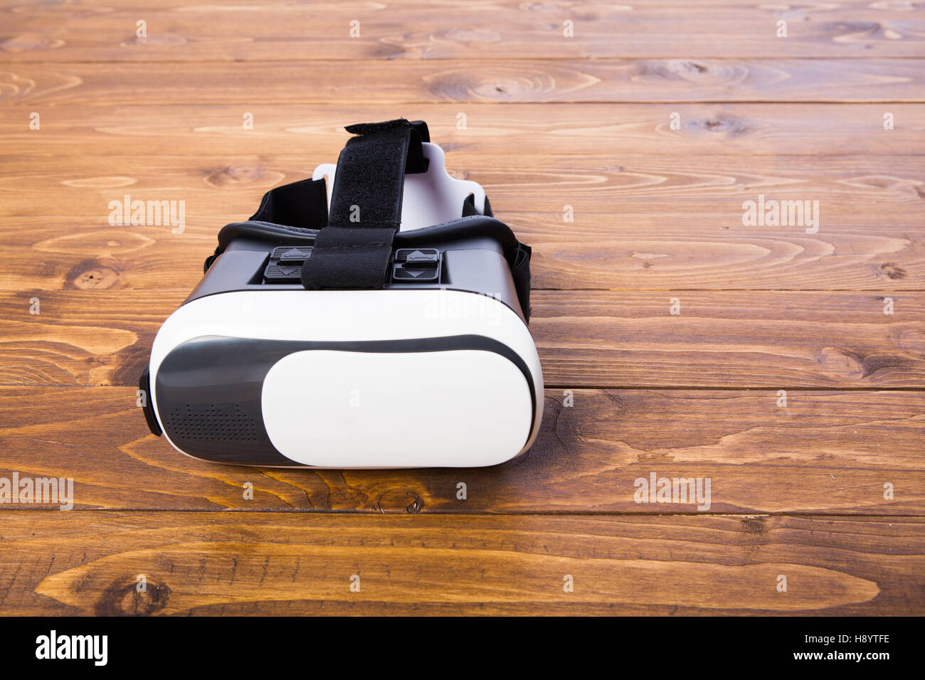 front side of a vr headset, isolated on wooden floor background, close up Stock Photo