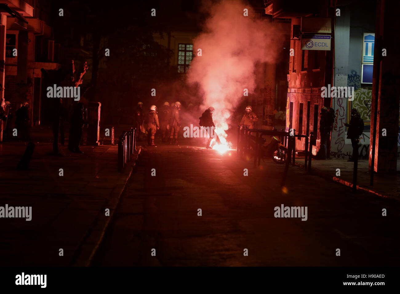 Athens, Greece. 17th November 2016. A police officer kicks a fire bomb to the side. The protest march from the Athens Polytechnic to the US embassy that is held as part of the 1973 Athens Polytechnic uprising commemoration turnt violent, when protesters who barricaded themselves inside the Polytechnic attacked riot police officers with stones and petrol bombs. Credit:  Michael Debets/Alamy Live News Stock Photo