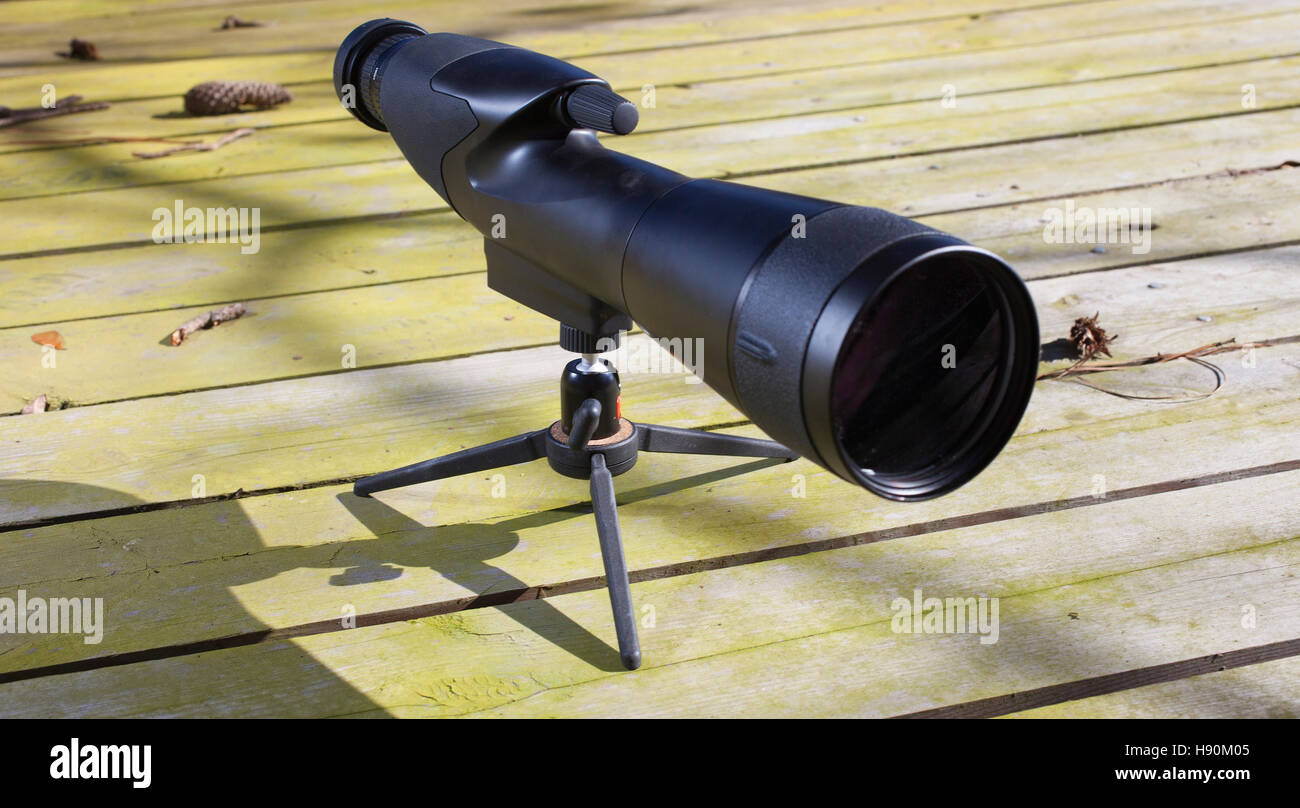 Black spotting scope and tripod on wood boards Stock Photo Alamy