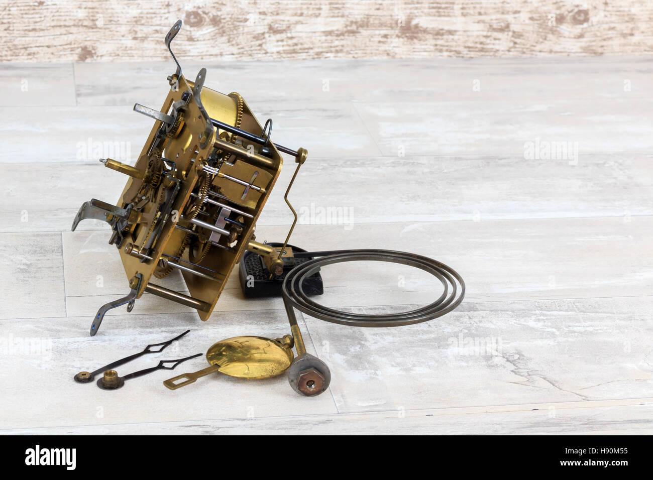 Old brass clock mechanism with pendulum, chime spring and three small screwdrivers Stock Photo