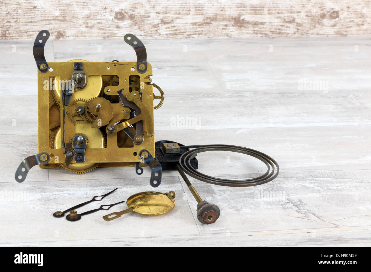 Old brass clock mechanism with pendulum, chime spring and three small screwdrivers Stock Photo