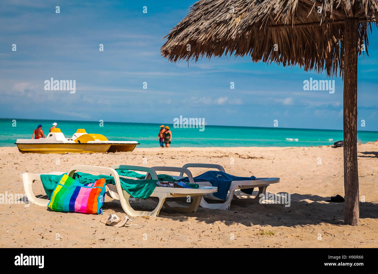 Beach chairs under the shade of a straw hut Stock Photo Alamy