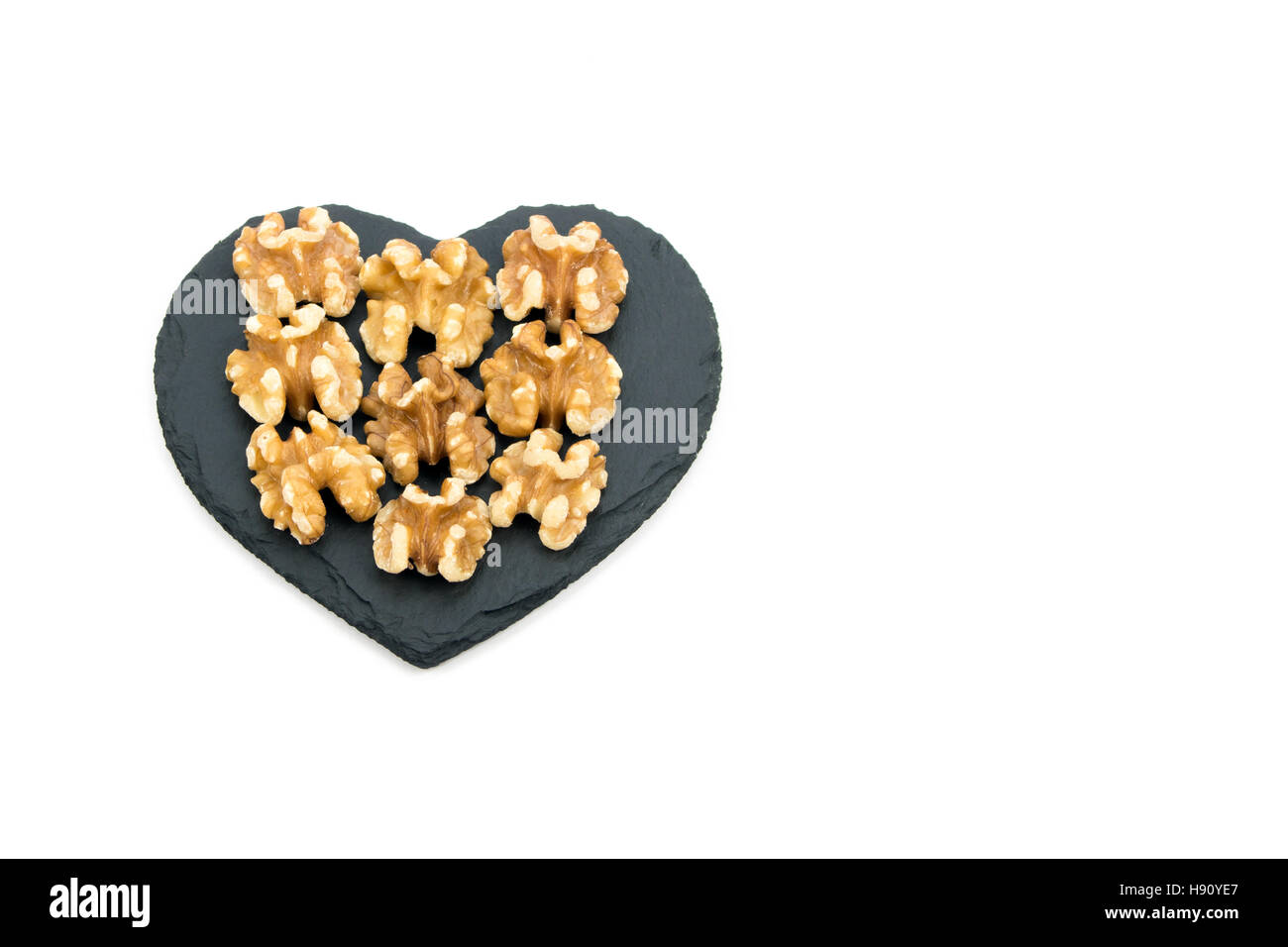 Walnuts on heart shaped black slate Stock Photo
