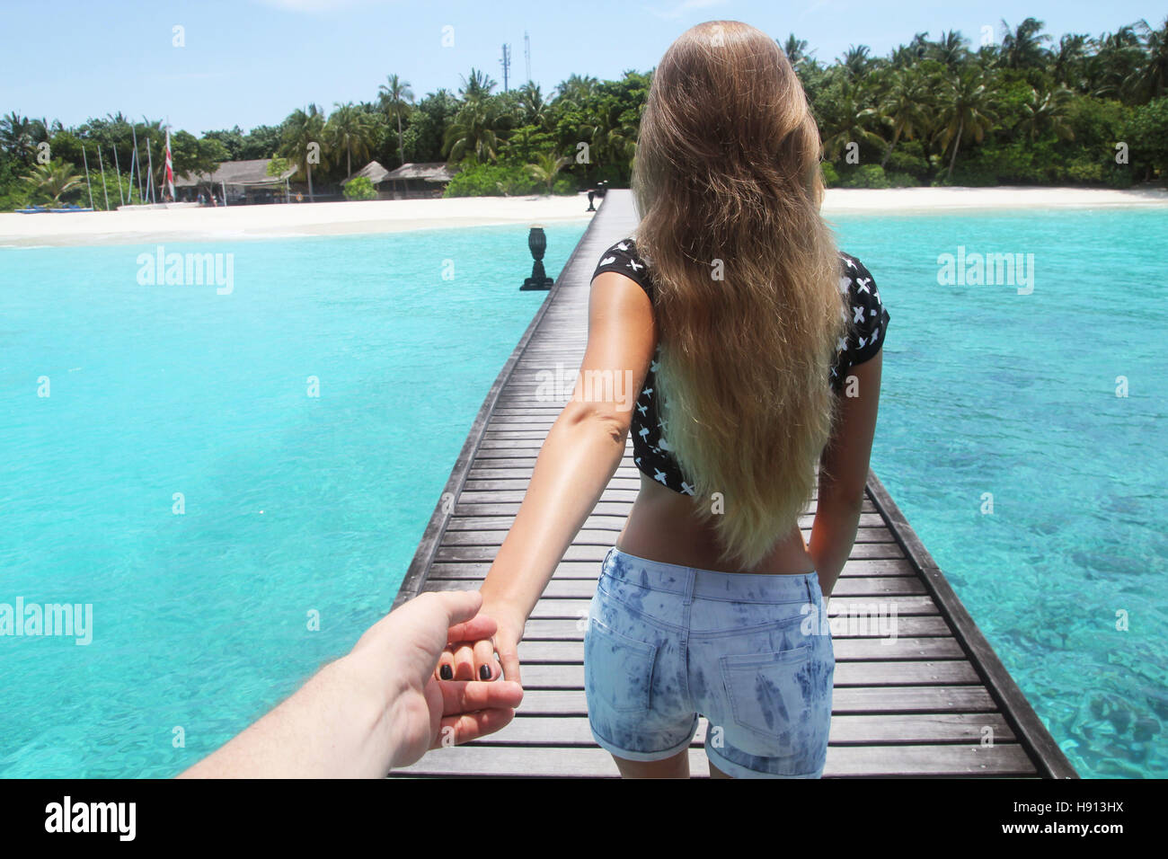 photoshoot of a blondie girl on a white sand beach in maldives Stock Photo