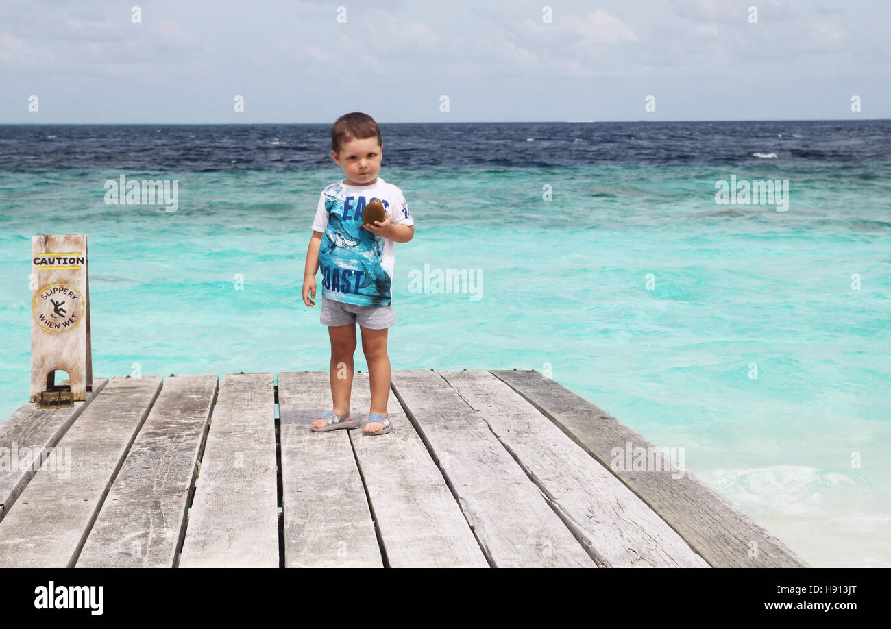 3 year old kid at the beach on maldives island white sand blue ocean Stock Photo