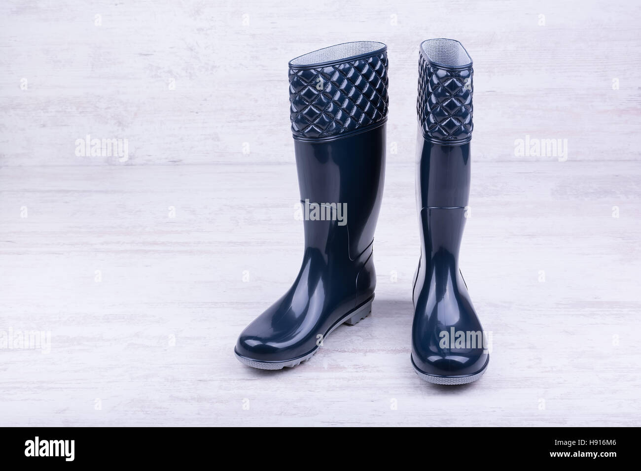 Pair of blue rubber boots on white wooden background Stock Photo - Alamy
