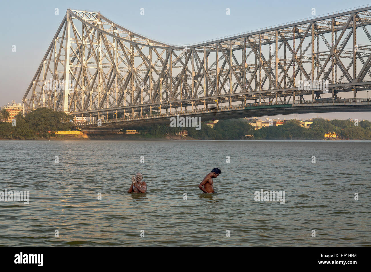 People take bath on river Hooghly (Ganges) near Howrah bridge close to Mallick ghat, Kolkata, India. Stock Photo