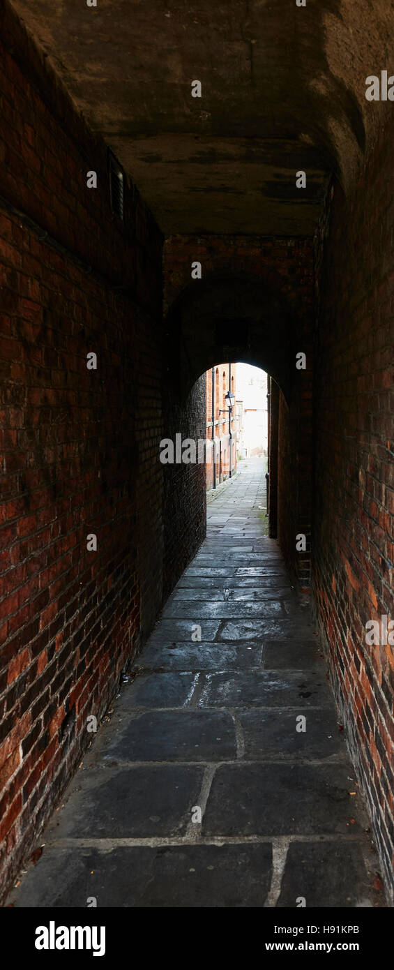A narrow alleyway forms a tunnel leading from the high street in Bedale North Yorkshire Stock Photo