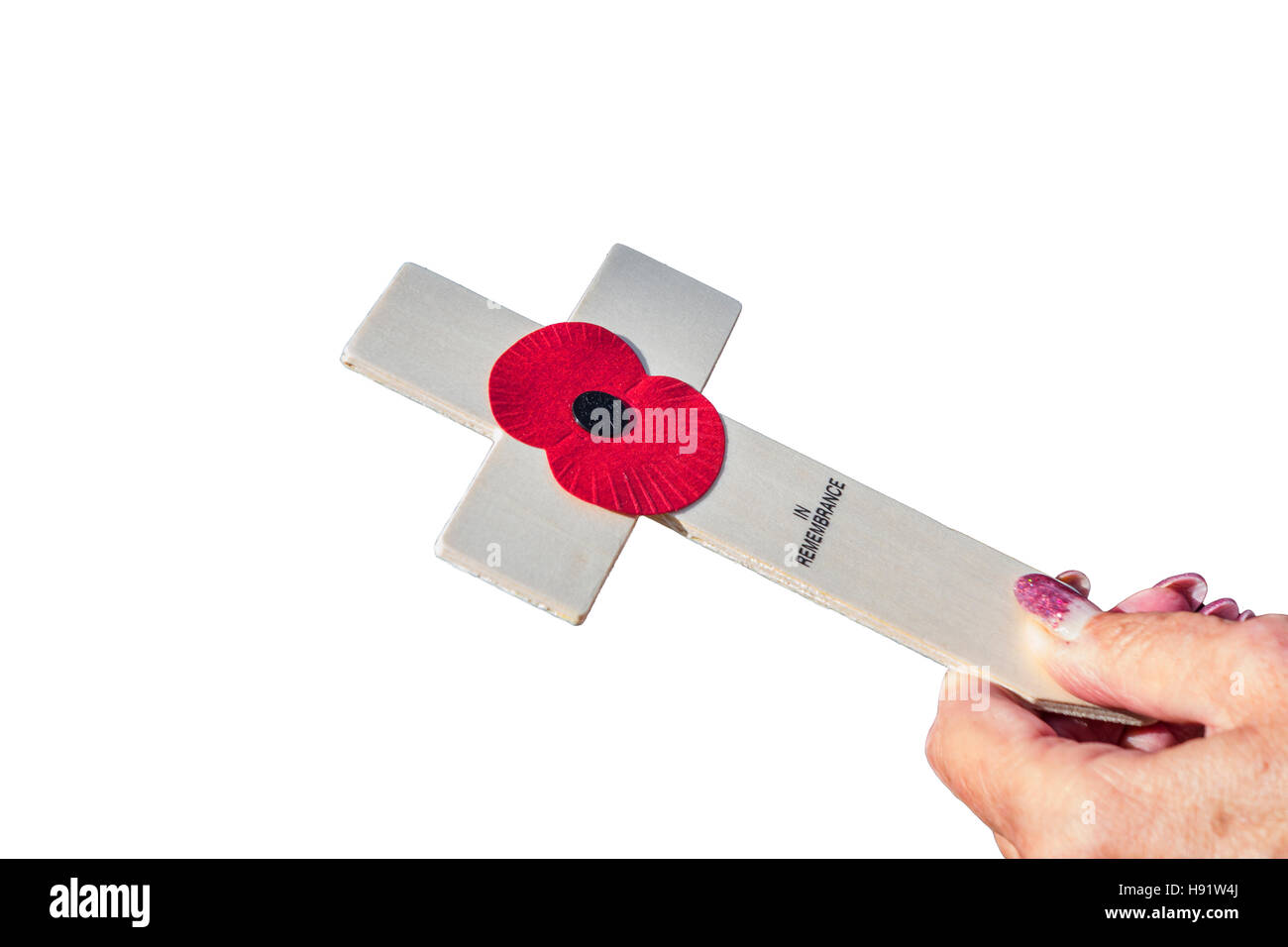 Female hand holding a wooden poppy appeal cross. Stock Photo
