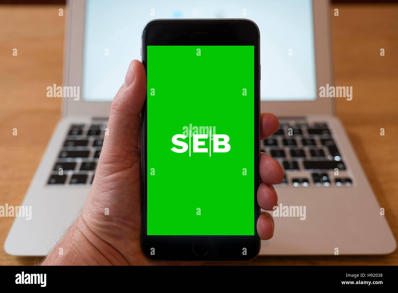 Using iPhone smart phone to display website logo of SEB, Skandinaviska Enskilda Banken, Swedish financial group. Stock Photo