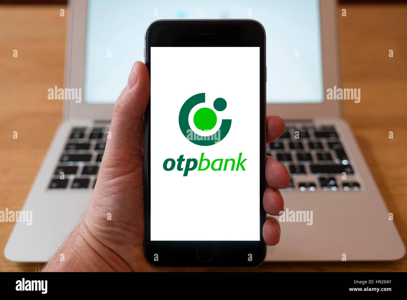 Using iPhone smart phone to display website logo of OTP bank a large independent financial services provider in Central ,  Eastern Europe Stock Photo
