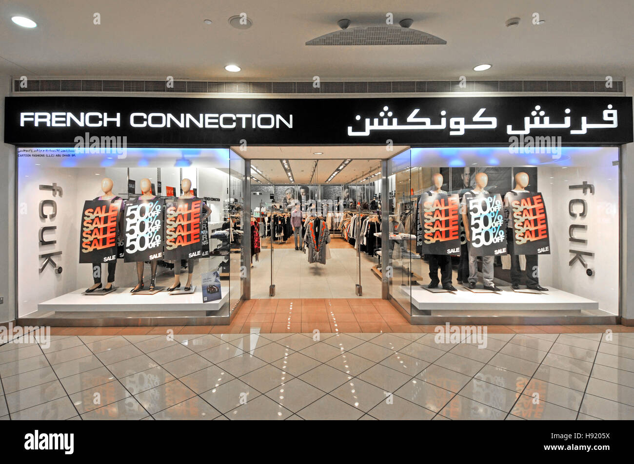 French Connection shop Abu Dhabi UAE middle east Marina shopping mall fcuk brand front window display interior bilingual multilingual sign Stock Photo
