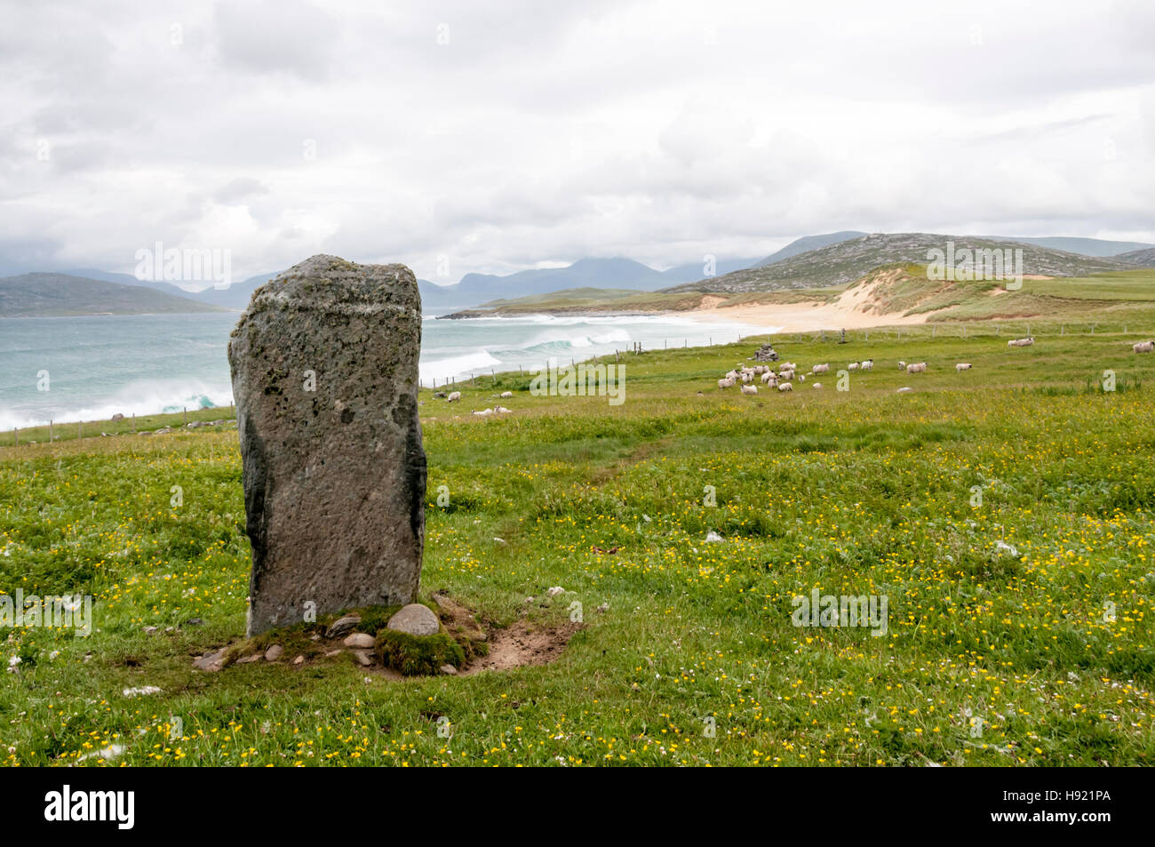 Clach Stèinigidh standing stone in front of Tràigh Mhòr beach on the west coast of South Harris in the Outer Hebrides. Stock Photo