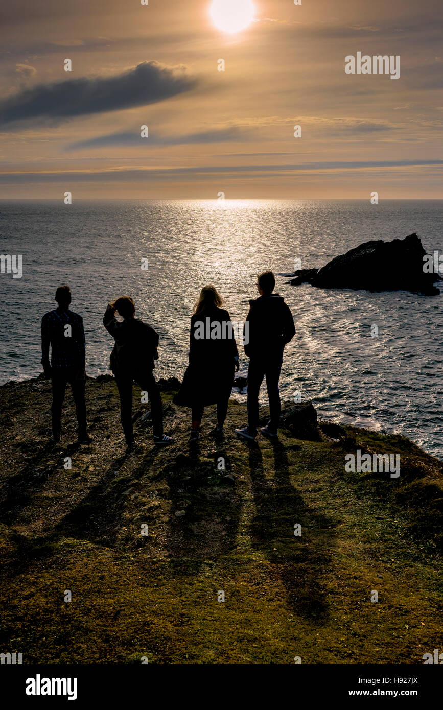 Four friends enjoy a spectacular summer evening on East Pentire headland in Newquay in Cornwall. Stock Photo