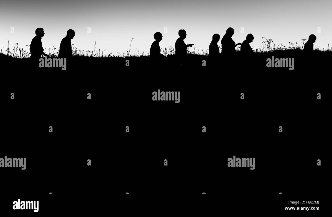 The silhouette of people walking along a path on East Pentire Headland ...